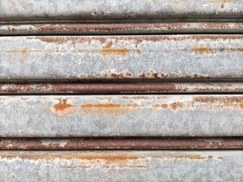 Horizontal parallel metal ridges gray texture with rustic, weathered, oxidized iron. Corroded surfaces. Suitable for industrial backgrounds or textured design projects.