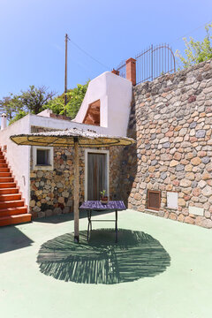 Bamboo parasol casting shadow on green courtyard floor