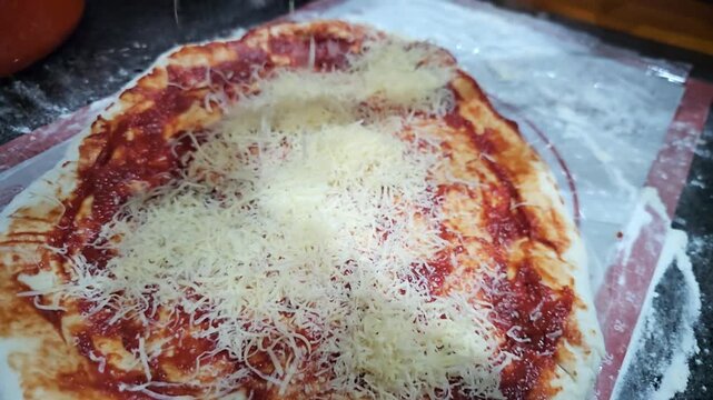 Preparing a cheese-covered pizza with sauce and crust in a kitchen setting