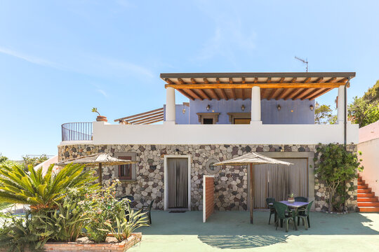 Stone villa with pergola and patio seating area
