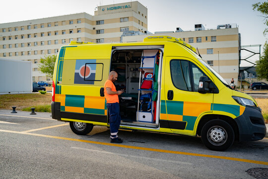Paramedic checking phone next to ambulance