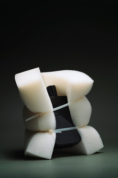 Perfume bottle and a sponge fastened with a plastic cable tie