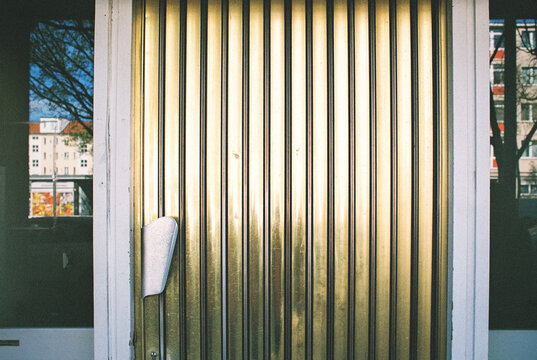 Gold corrugated metal door with handle in sunlight
