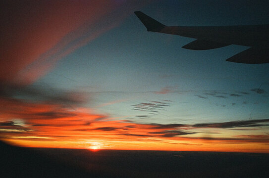 Sunset sky viewed from airplane window with wing