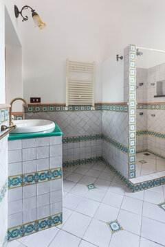 Patterned tile fills a sunlit bathroom corner