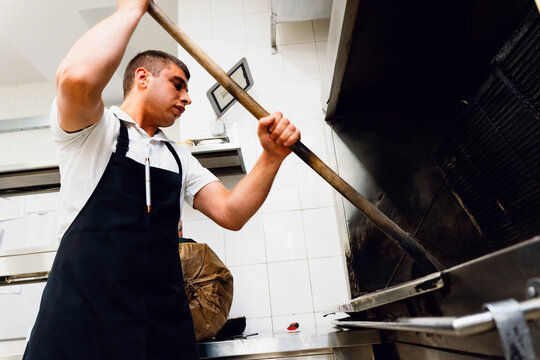 Cook Tending a Wood-Fired Grill