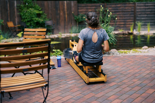 middle aged women working out outdoors with rowing fitness machine