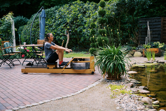 middle aged women working out outdoors with rowing fitness machine
