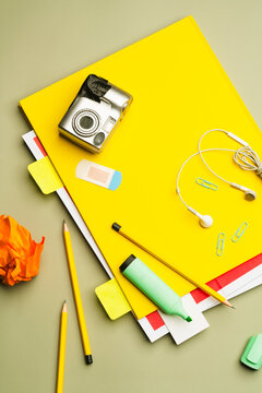 Messy collection of stationery and daily objects on yellow notebook