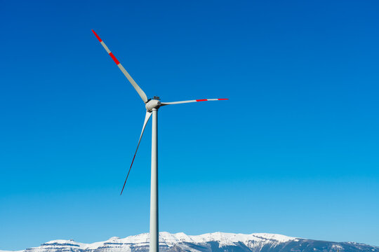 Wind Turbine Over Snowy Peaks