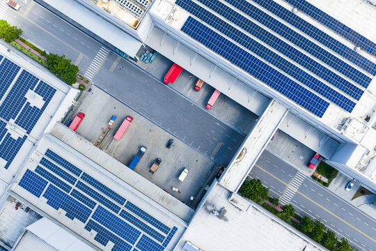 solar rooftop warehouse with loading trucks at dock