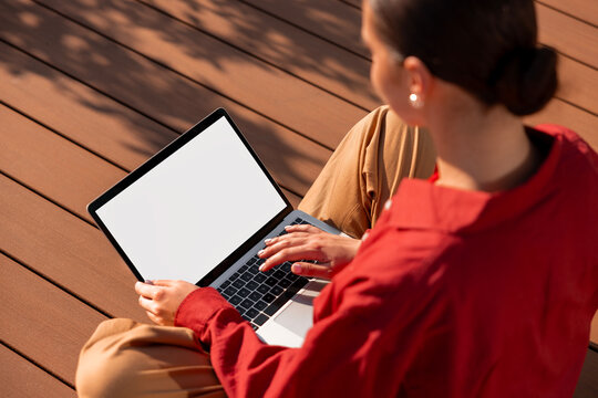 Woman using laptop mockup with blank white screen on deck