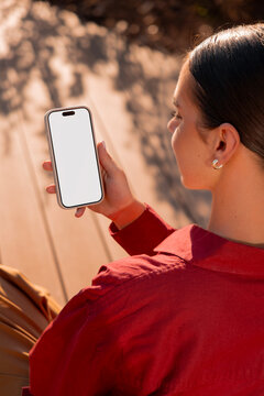 Woman viewing smartphone mockup with white screen in sunlight
