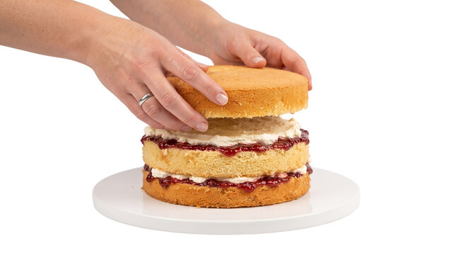Baker placing sponge cake layer on jam cream cake, homemade Victoria sponge assembly, dessert making process isolated PNG with Transparent Background