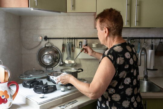 Senior Woman Cooks Homemade Food in Kitchen During the Day