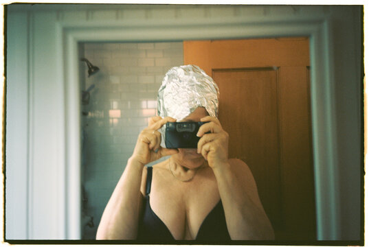 Woman Taking a Selfie in a Bathroom While Wearing Foil on Her Head