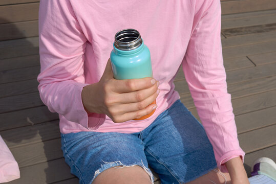 Anonymous woman holding reusable water bottle