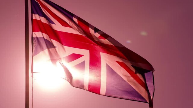 Sunlight Through the British Flag. The Big State Flag is illuminated by the sun and flutters epically in the wind against the rising sun