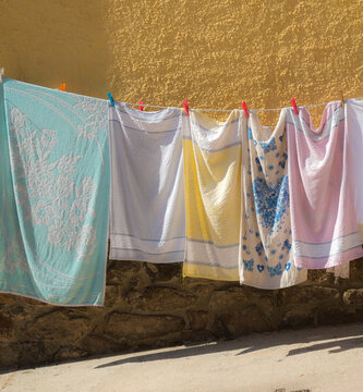 Italy, Sardinia, Castelsardo.  Colourful towels hanging out to dry on clothesline.