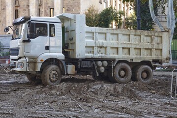 Heavy Tipper Dump Truck on Muddy Ground at Urban Construction Site  © Анна Хмеленок
