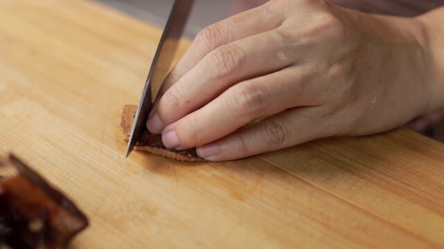 Woman slicing shiitake mushroom on a wooden board