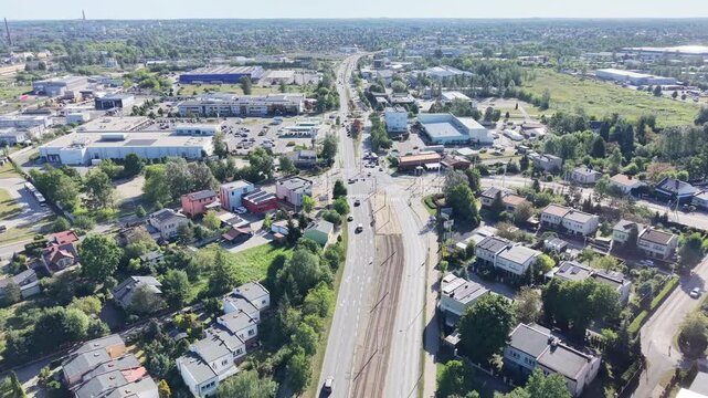 Large roadway separating buildings and urban greenery