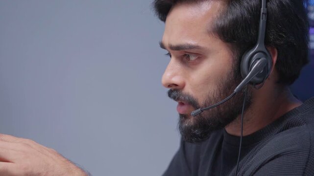 Businessman wearing headphones, is providing customer service online using a computer and AI powered management system. Call center sales, and customer communication. Coworking, telemarketing