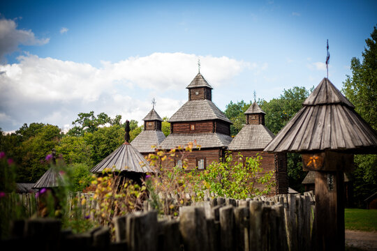 Traditional wooden Ukrainian church surrounded by historic wooden fences and rural architecture at the National Museum of Folk Architecture and Life of Ukraine in Pyrohiv.