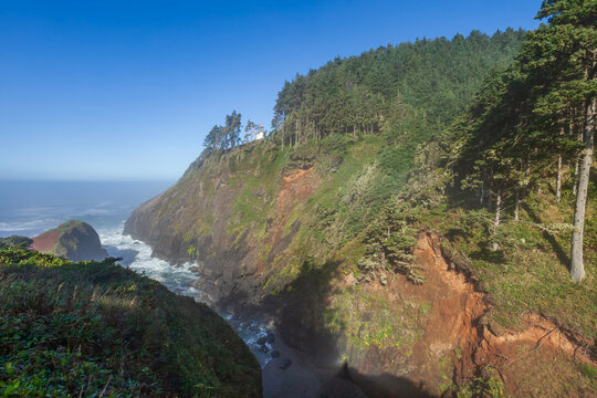 Beautiful scenic view of a historic lighthouse on a high rocky cliff over the ocean at sunny day