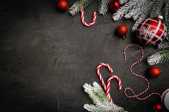 Christmas and New Year background with a festive scene with gold and red Christmas ornaments and fir tree branches on a dark background, symbolizing holiday spirit and elegance.