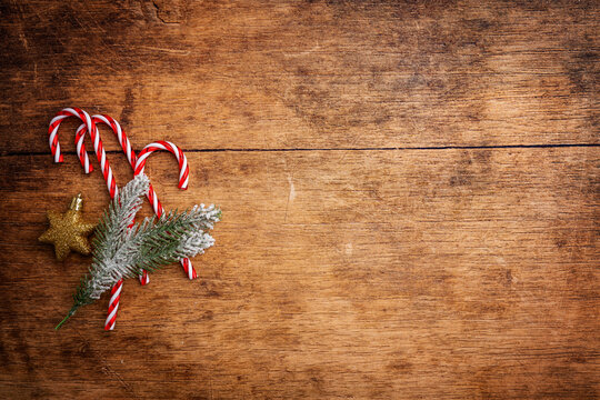 Christmas and New Year background with Candy canes with holiday decorations and fir branches on a dark wooden background, banner for holiday screen. Holiday card with space for text