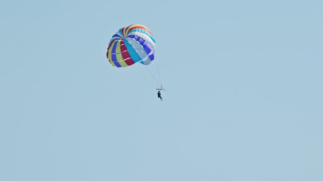 man parasailing over the sea in barcelona