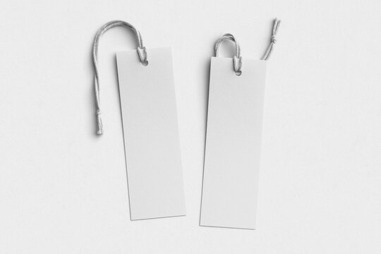 Two blank white bookmarks with cotton string on textured paper background, flat lay mockup