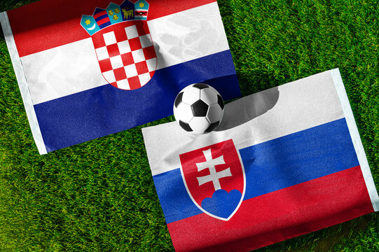 Croatia vs. Slovakia football match. National flags on green grass with soccer ball in the middle. Football background for international match.