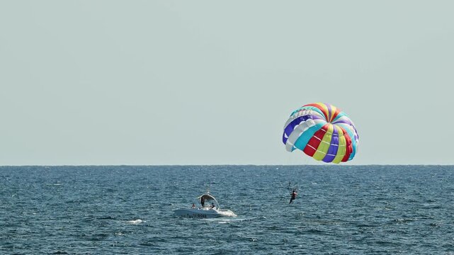 man parasailing over the sea in barcelona