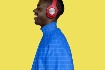 Smiling man in red headphones wearing blue jacket on yellow background © Rawpixel.com