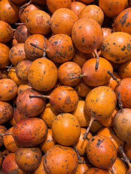 Pile of fresh yellow passion fruits ( markisa konyal) at traditional market background 