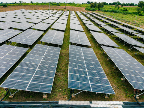 Aerial view of a large solar farm with rows of photovoltaic panels installed on green grassy fields in Ogun State, Nigeria.