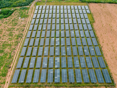 Aerial view of a large solar farm with rows of photovoltaic panels installed in a rural landscape in Ogun State, Nigeria.