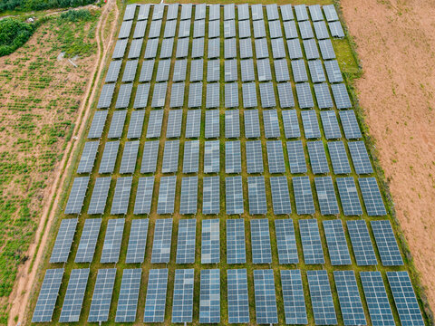 Aerial view of a large solar farm with rows of photovoltaic panels installed in a rural landscape in Ogun State, Nigeria.