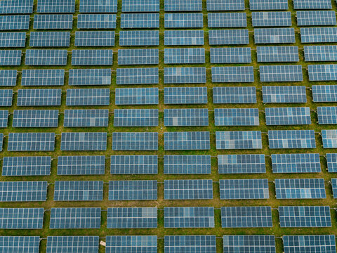 Aerial view of a large solar farm with rows of photovoltaic panels arranged in a grid pattern across the landscape in Ogun State, Nigeria.