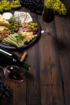 Red wine glasses and bottles with cheese board