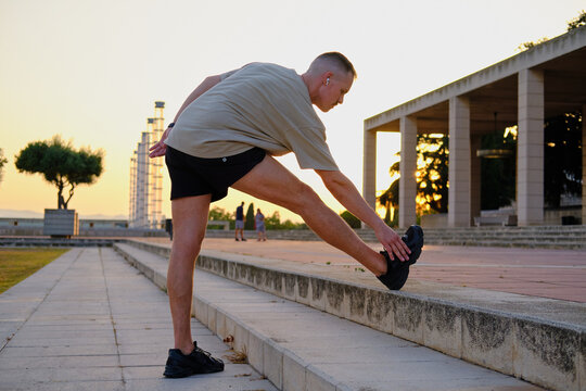 side view of Man stretching outdoors preparing for exercise in barcelona