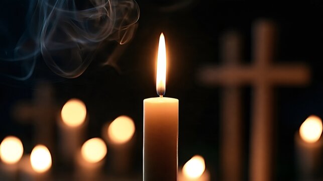 Candle burning brightly with a flickering flame and rising smoke, symbolizing faith, prayer, remembrance, and spirituality against a dark background with blurred crosses and other glowing candles