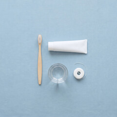 Obraz premium Overhead flat lay of oral hygiene essentials on soft pastel blue background