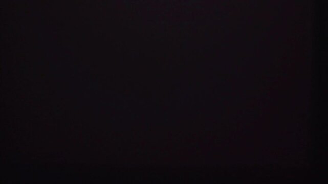 Abstract dark purple background with subtle shifting light patterns.