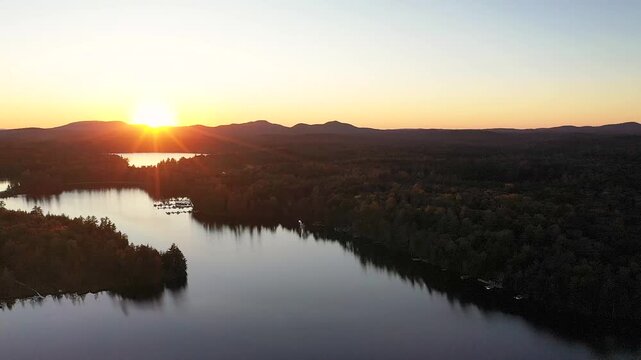 Sunset in early fall over Fish Creek Pond NY Adirondacks aerial drone descending
