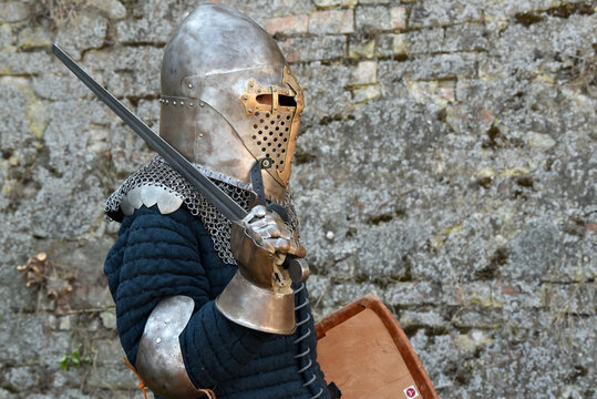 Medieval knight in full armor holding a sword and shield