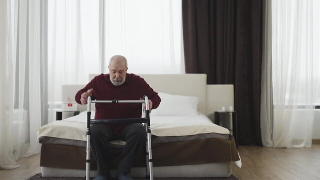 Elderly man with disability moving with walking frame at home, rehabilitation