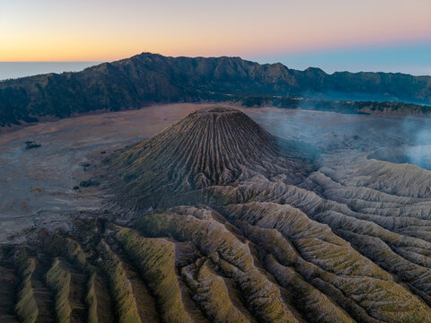 Aerial view of Mount Bromo volcano with its rugged crater and volcanic landscape at sunrise in the caldera of Bromo Tengger Semeru National Park, Kecamatan Tosari, Jawa Timur, Indonesia.